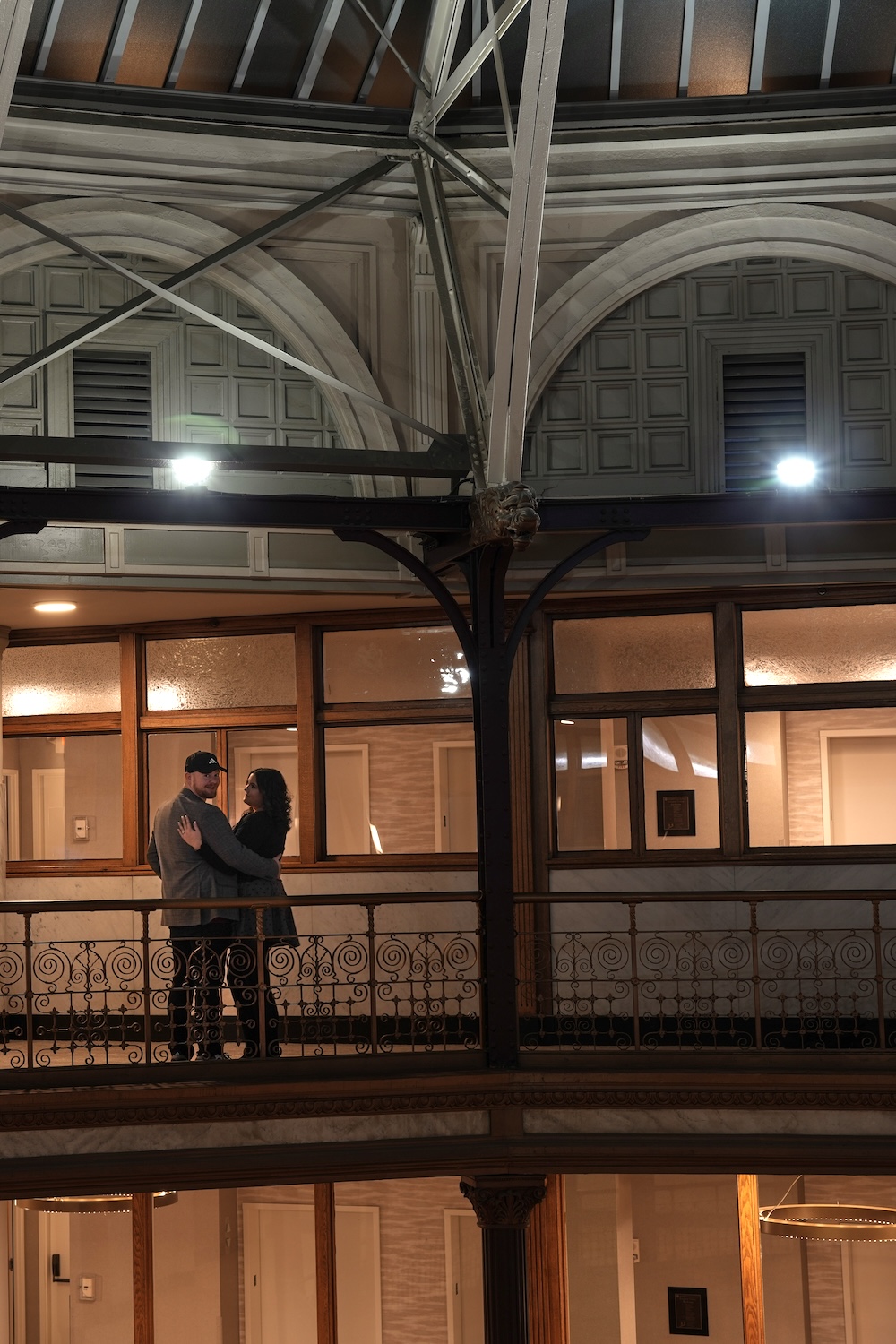 Photo of couple on an upper balcony inside the Cleveland Arcade, surrounded by historic architecture.
