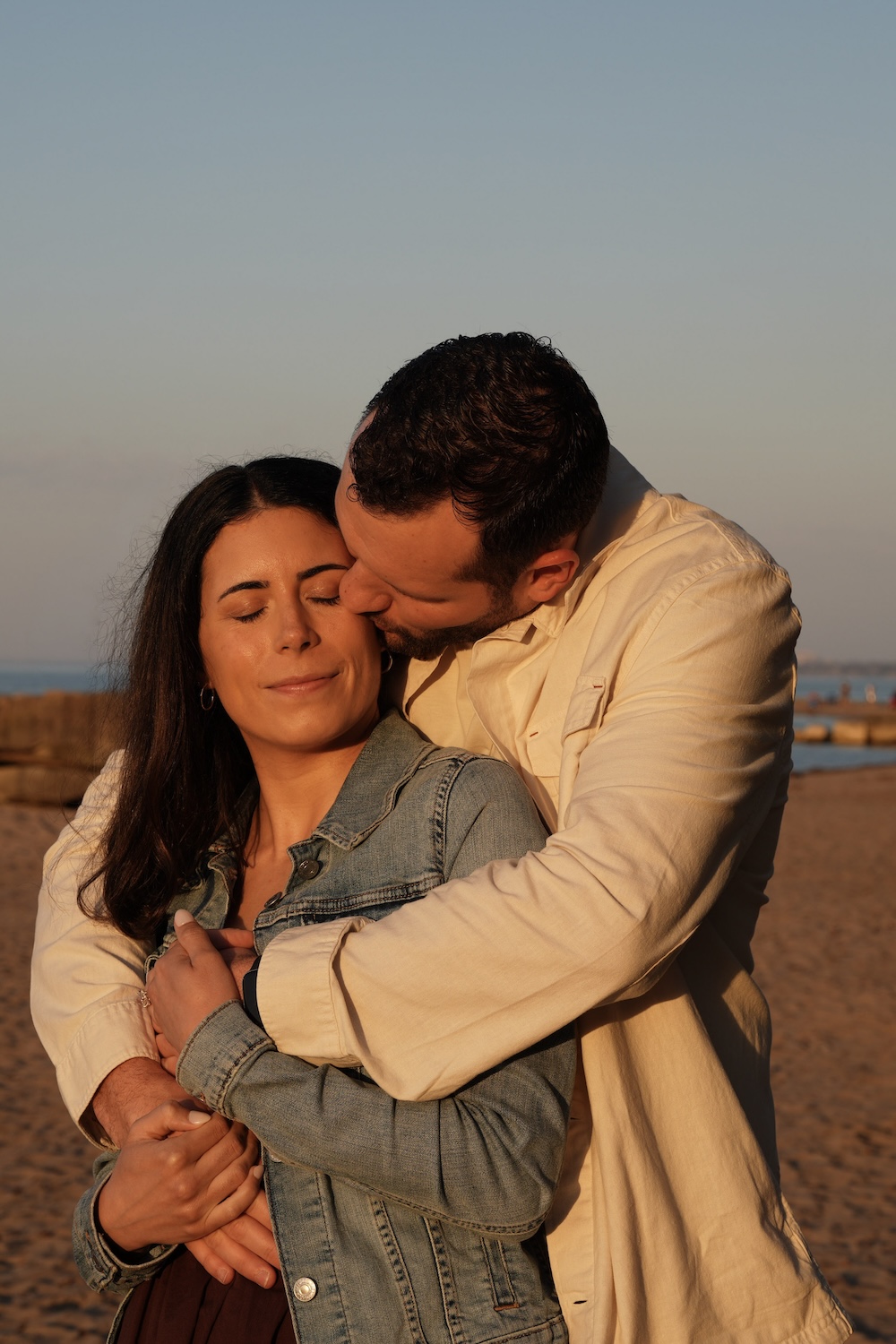 Portrait of an engaged couple embracing in the warm evening light at Huntington Beach in Bay Village, Ohio.