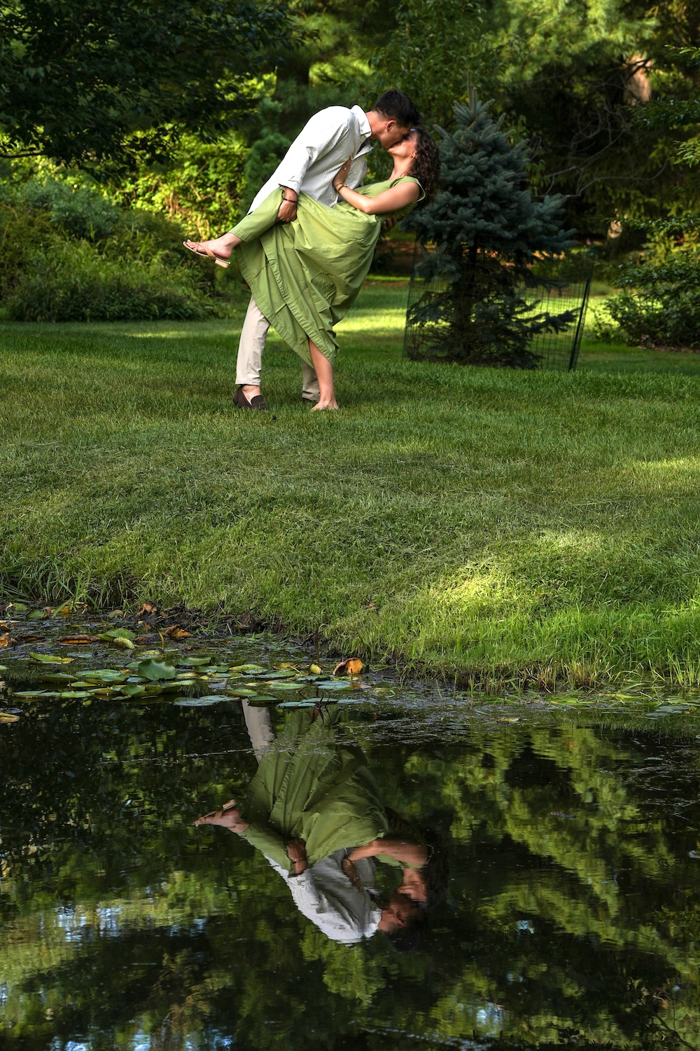 Couple embracing in the garden above a pond reflection during their Northeast Ohio engagement photo session.