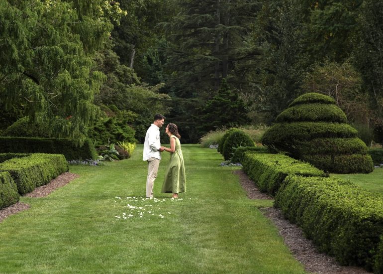 Wide view of a couple on a garden path bordered by hedges at Schoepfle Garden in Ohio.