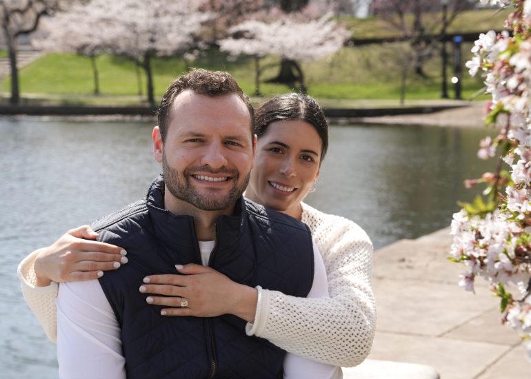 Photo of couple embracing beside Wade Lagoon in spring.