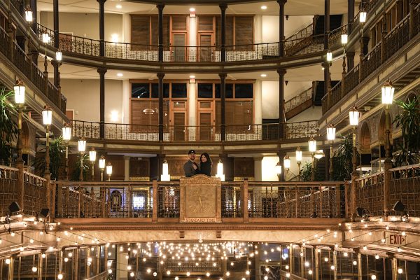 Couple together on an upper balcony inside the Cleveland Arcade, surrounded by historic architecture.