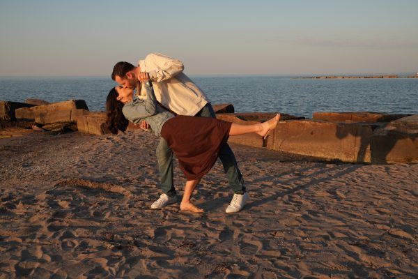 After engagement, photographer get a sunset photo of man and woman at Lake Erie along Huntington Beach.